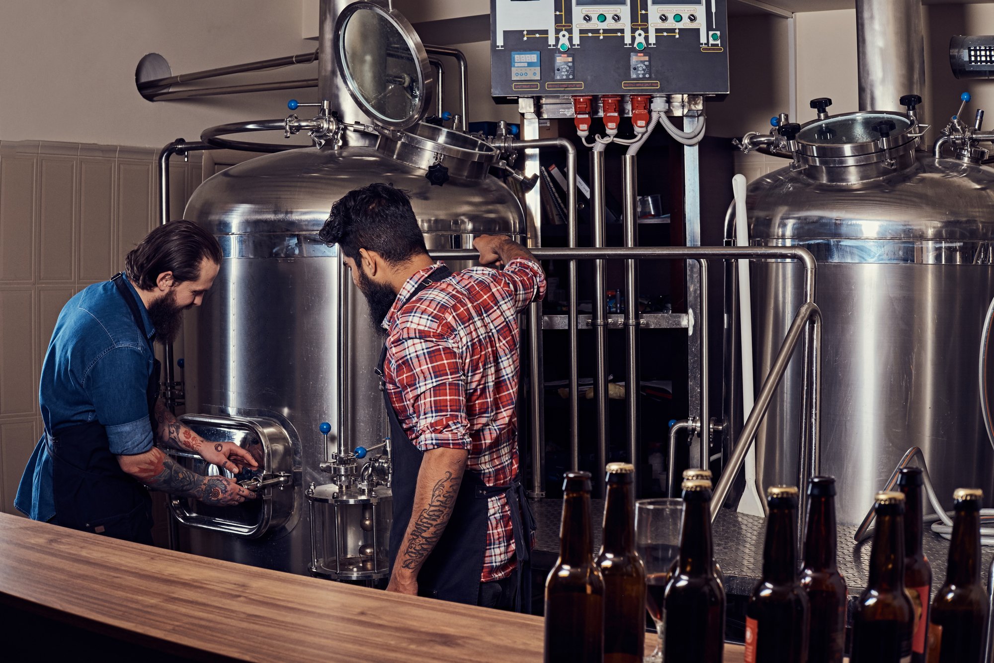 two-bearded-hipster-males-apron-working-brewery-factory